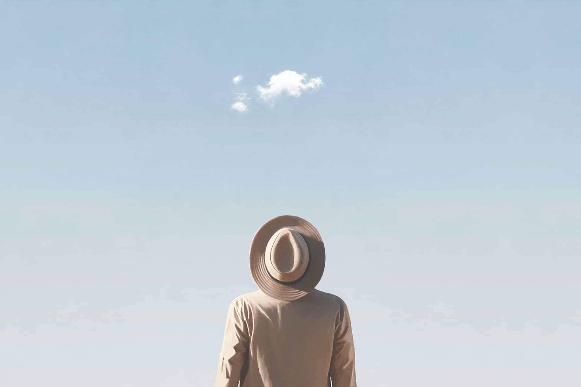 Man looking up a lone cloud in sky